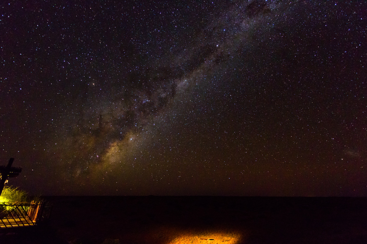 The light around the galactic core of the Milky Way fills the skies above the red dunes of the Kalahari, from our vantage point at Killiekrankie Desert Camp.  The light trails beneath are from a neighbour's torch, searching for the lions which were seen earlier on atop the dunes to the left.