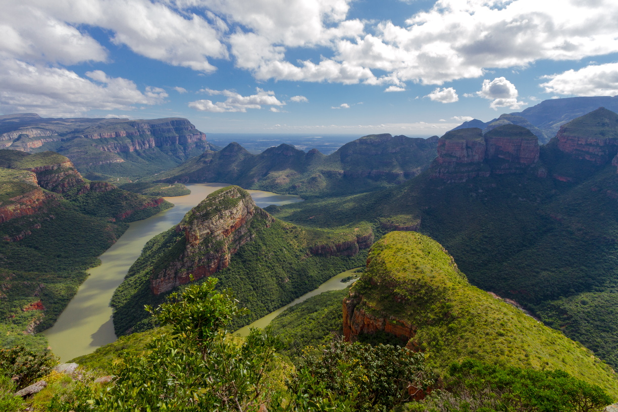 Under a beautifully patterned sky, the Three Rondavels rise up from the green floor and river of Blyde River Canyon, Mpumalanga, South Africa.