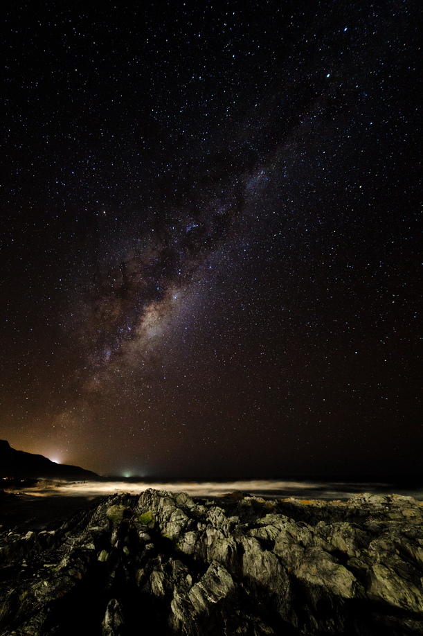 The Milky Way arcs downward to the raging seas of the Tsitsikamma coast, South Africa.